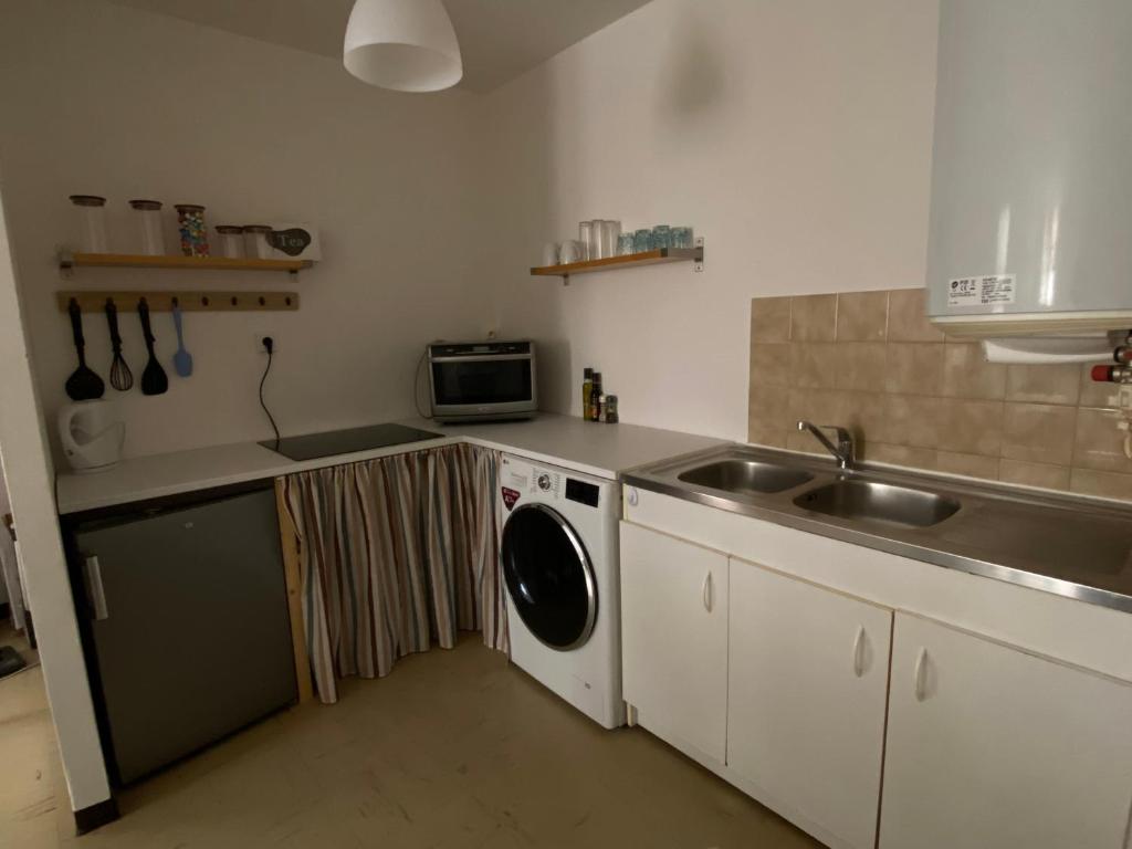 una cocina con fregadero y lavadora en Meilleur rapport qualité prix, en Nyons