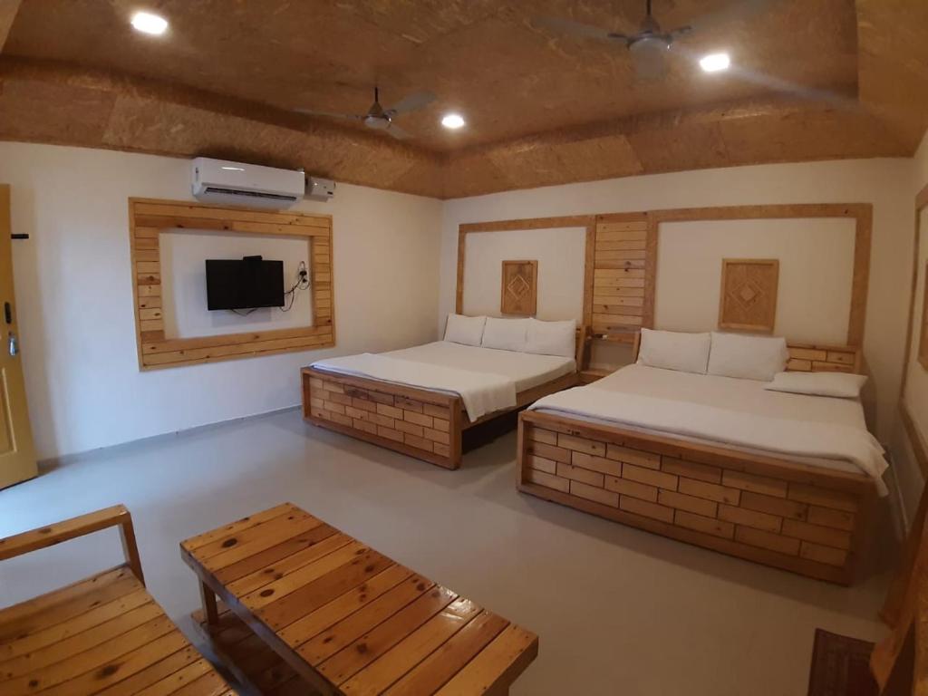 AnaimalaiRoyal Cottage & Party Hall的一间有两张床和一台电视的房间