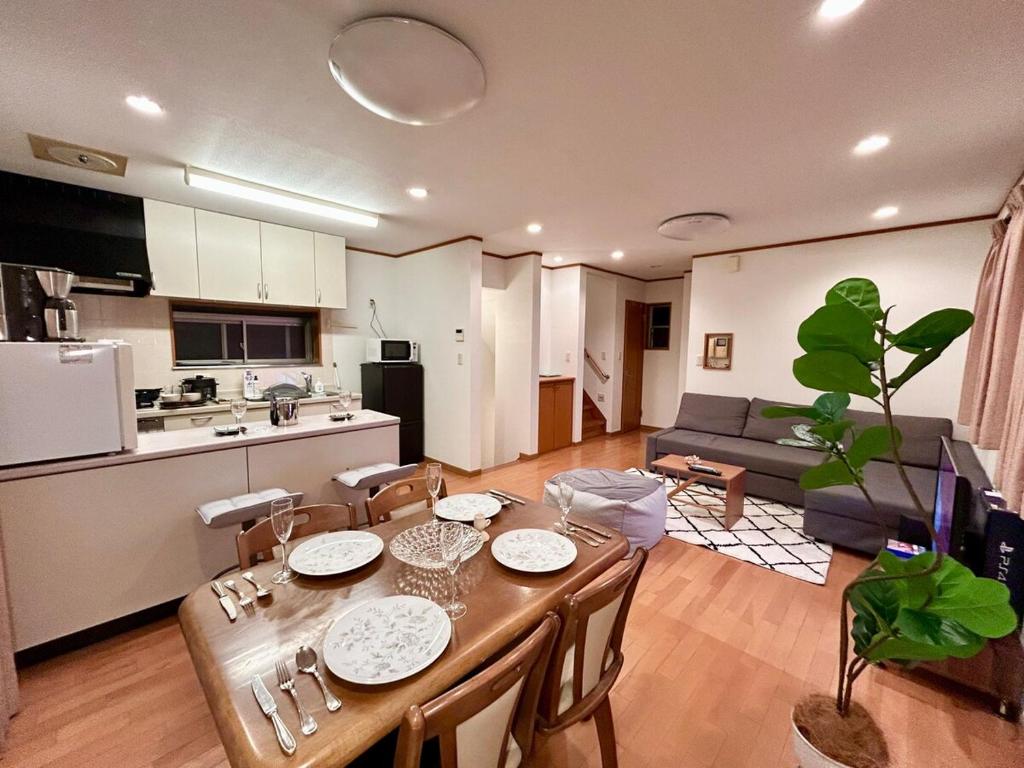 una cucina e un soggiorno con tavolo e sedie di AiES新小岩 新小岩站走8分 繁华商店街旁 最大12人 直达机场秋叶原新宿 旅馆内带免费停车场庭院露台 邻公园 a Tokyo