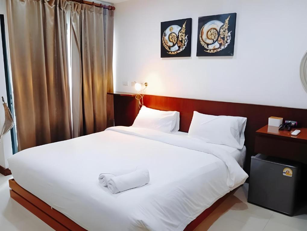 バンコクにあるYon INN Sukhumvit Soi 4 - BTS Nanaの白いシーツが敷かれたホテルの部屋にベッドが2つある