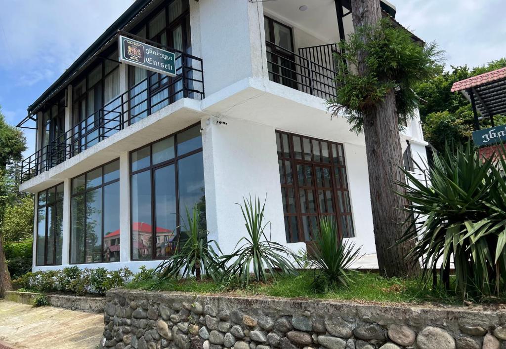 a white building with a sign in front of it at guest house buknari-eniseli in Chakvi