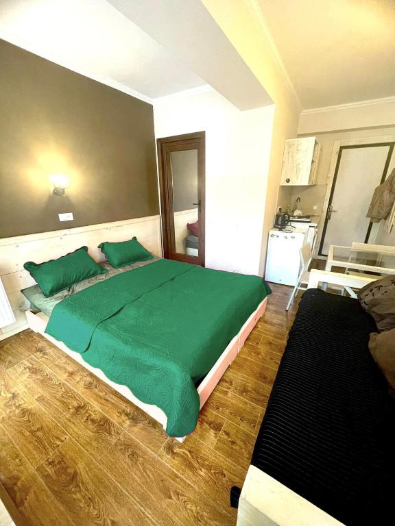 ein Schlafzimmer mit einem großen Bett mit grüner Bettwäsche in der Unterkunft Mgzavrebi Bakuriani in Bakuriani