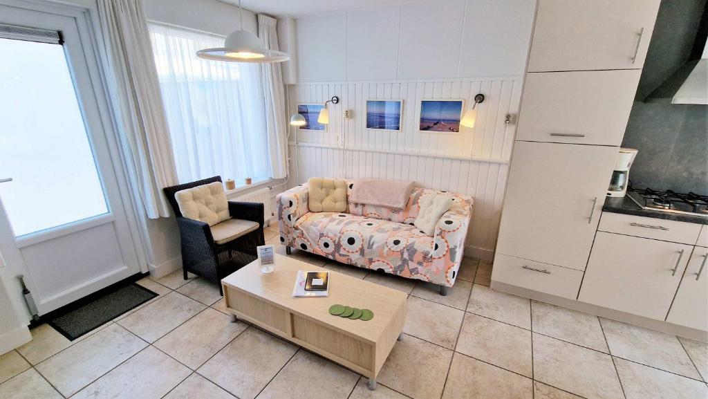 a living room with a couch and a table at Hello Zeeland - Vakantiewoning Schuurmanstraat 75b in Domburg