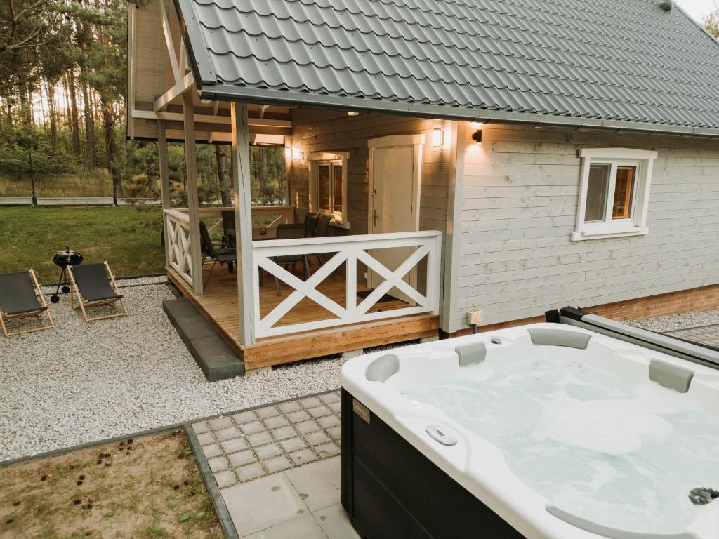 a large bath tub in front of a house at Zakątek Wygonin Jacuzzi & Sauna w Lesie - KASZUBY in Wygonin