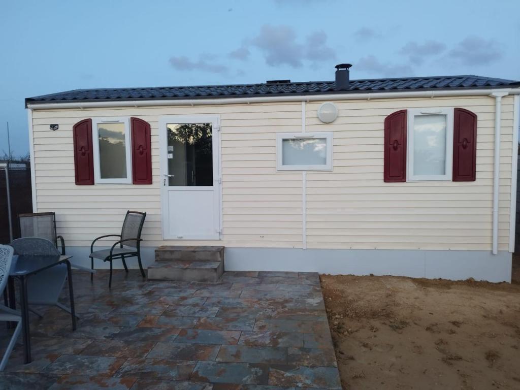 a white house with red doors and a patio at Móvilhome in Chiclana de la Frontera
