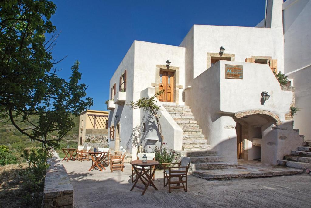 a white building with tables and chairs in front of it at Kapetan Manwlis in Káto Khóra