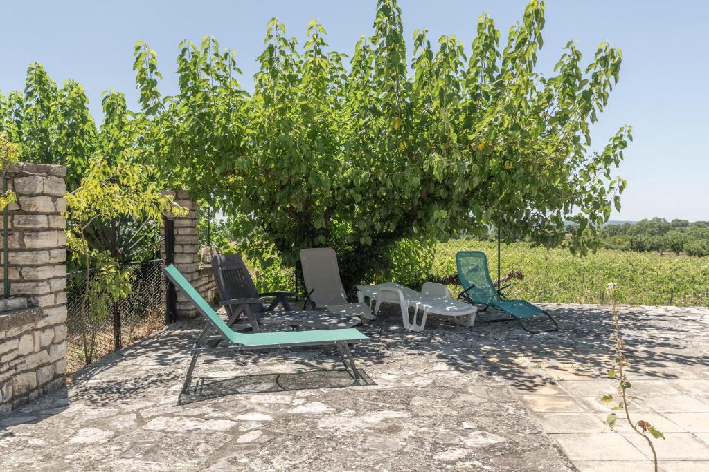deux chaises et une table sous un arbre dans l'établissement Chez Mémé De La Maréchale, à Orgnac-lʼAven