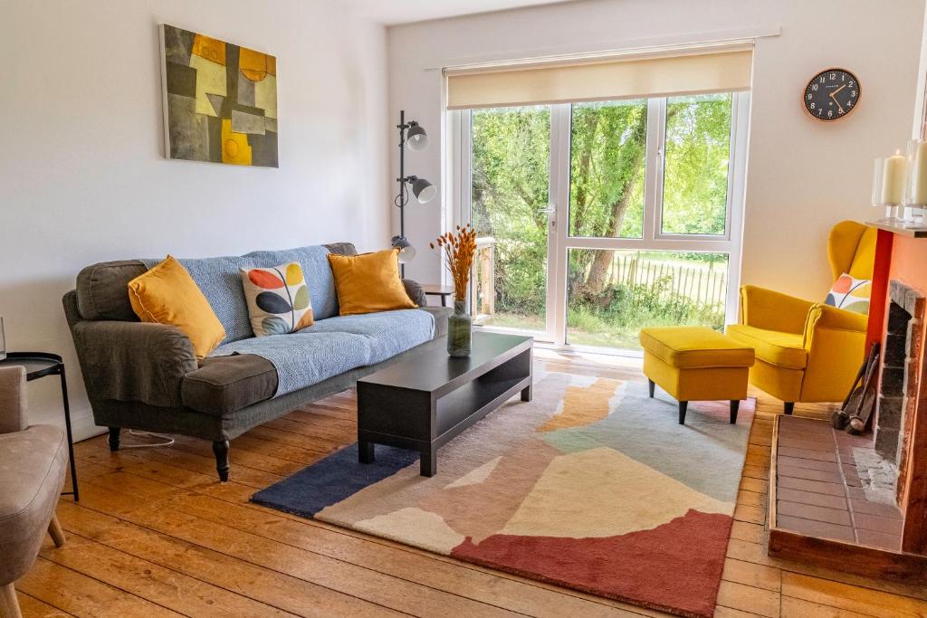 a living room with a couch and a table at Secluded 3 bed cottage in private parkland in Brockenhurst