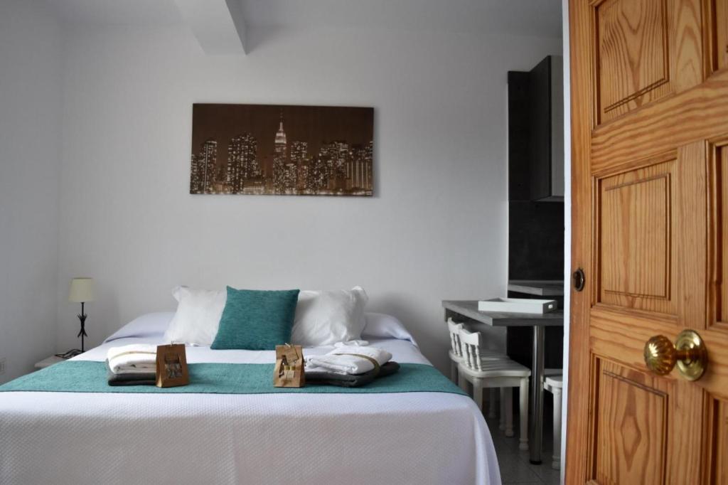 a bedroom with a bed with a painting on the wall at Apartamentos Sabare in Frontera