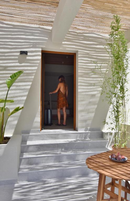 a woman standing in a window of a house at Swell Living Double Room in Asprovalta