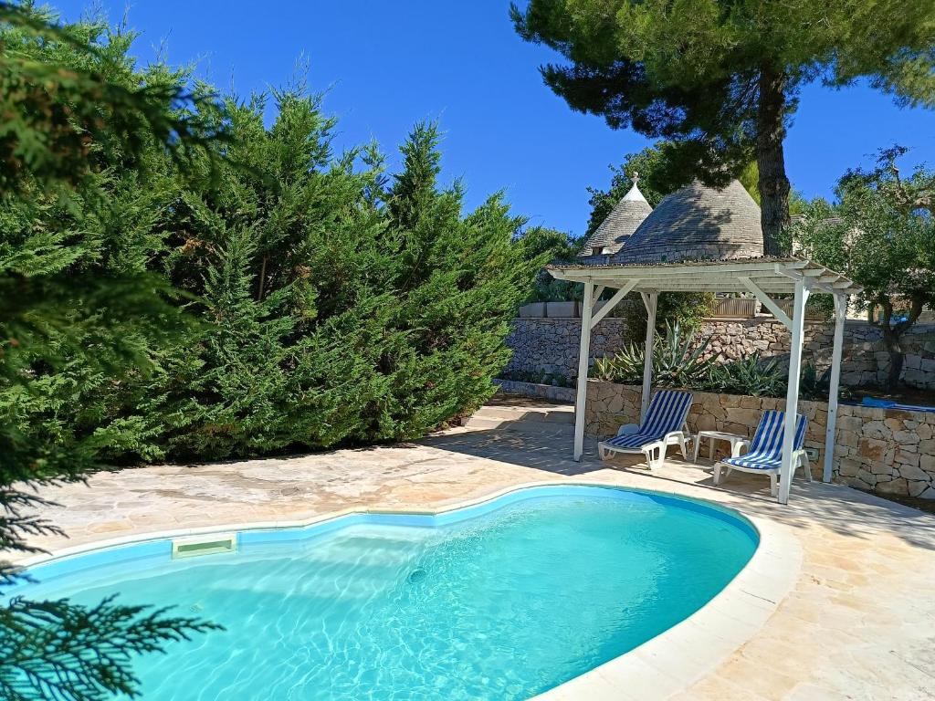 - une piscine avec un kiosque et 2 chaises dans l'établissement Villa Trullo Panorama, à Locorotondo