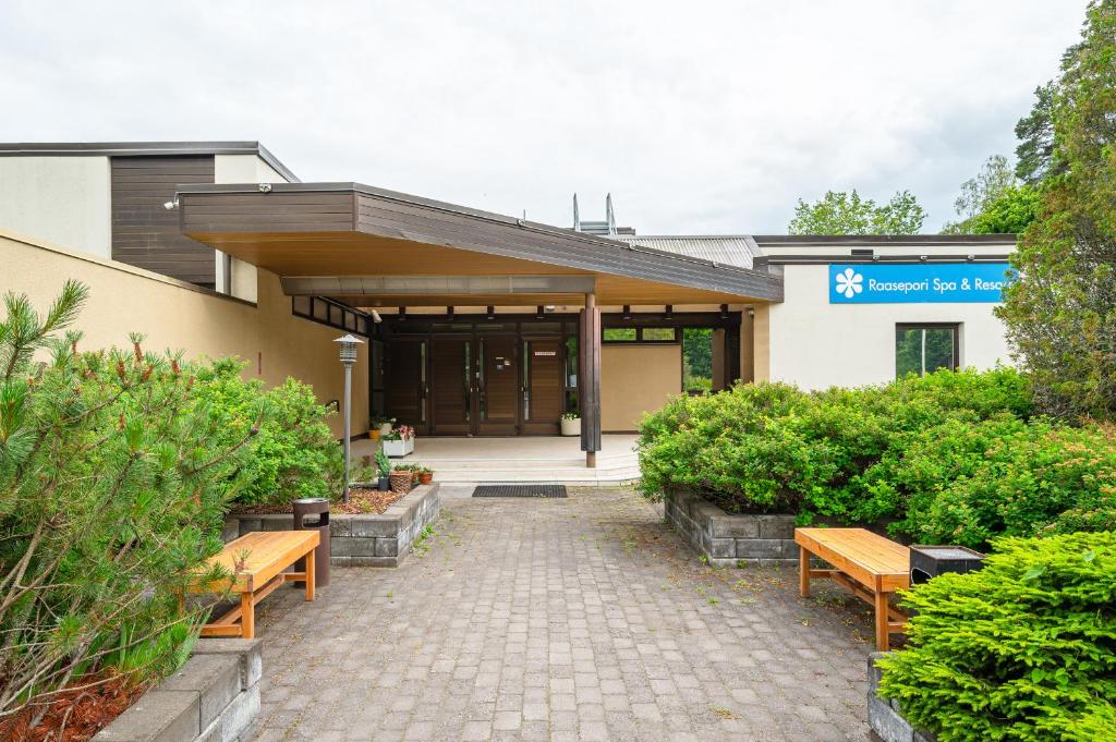 un edificio con due panchine davanti di Raasepori Spa & Kurssikeskus a Raseborg
