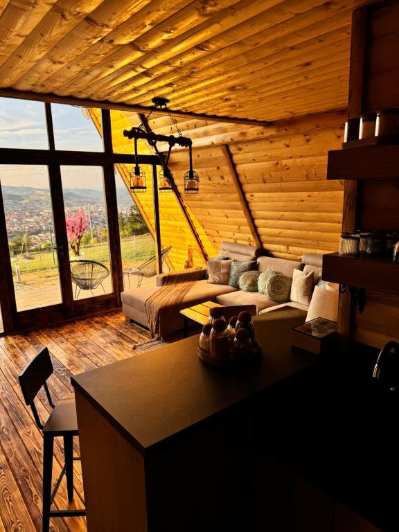 a living room with a couch and a large window at Cozy Cabin House in Novi Pazar