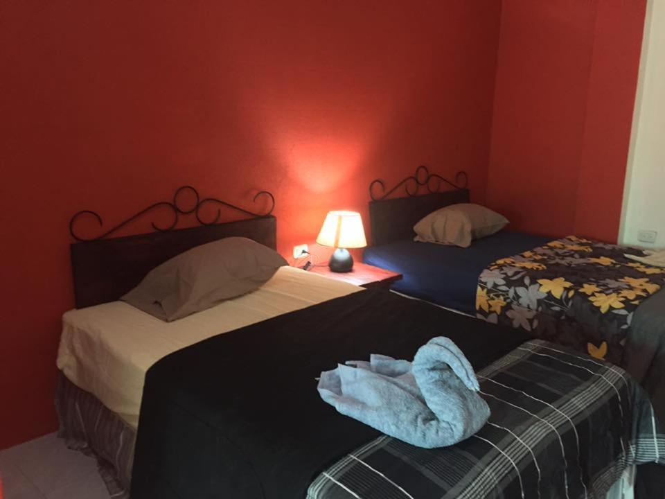 a room with two beds with a towel laying on the bed at Alojamiento D'Rosales in Cobán