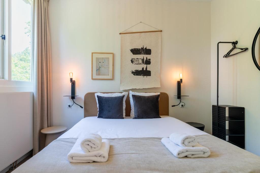 a bedroom with a bed with towels on it at Utrecht City Apartments - Maliesingel in Utrecht