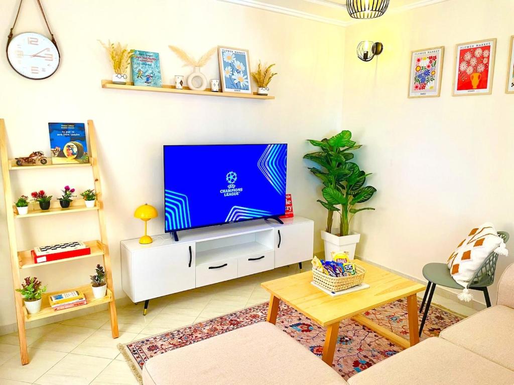 a living room with a tv on a white cabinet at Chic Design Stay With a Chocolate Welcome Gift in Agadir