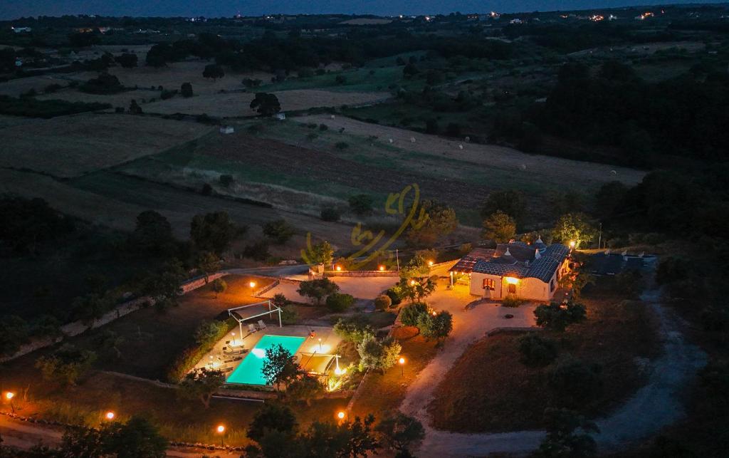 une vue aérienne d'une maison avec piscine la nuit dans l'établissement TD Trulli Altura with Pool & Stunning Sunsets, à Martina Franca