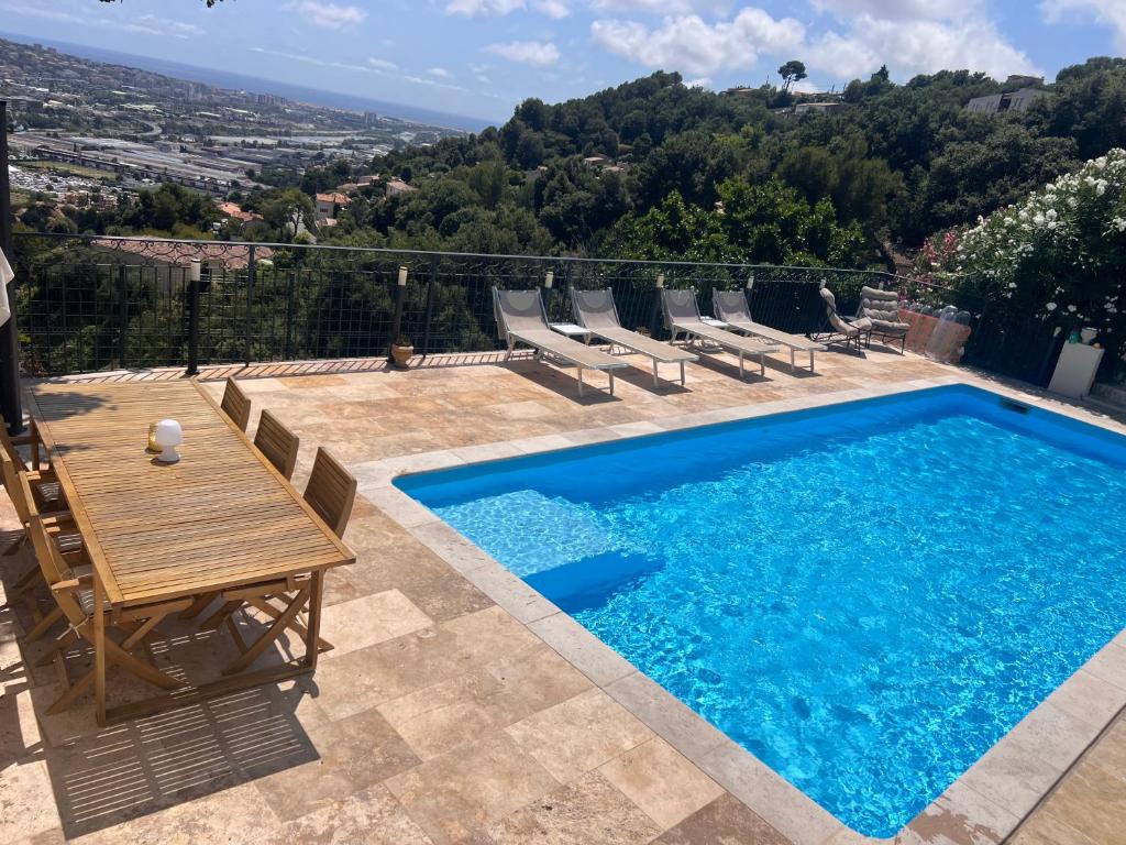 - une piscine avec une table et des chaises à côté dans l'établissement Studio 2 Personnes Saint Laurent du Var Montaleigne, à Saint-Laurent-du-Var