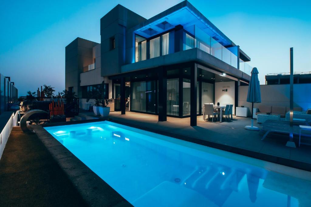 a house with a swimming pool in front of it at Villa Gold Star Meloneras in Meloneras