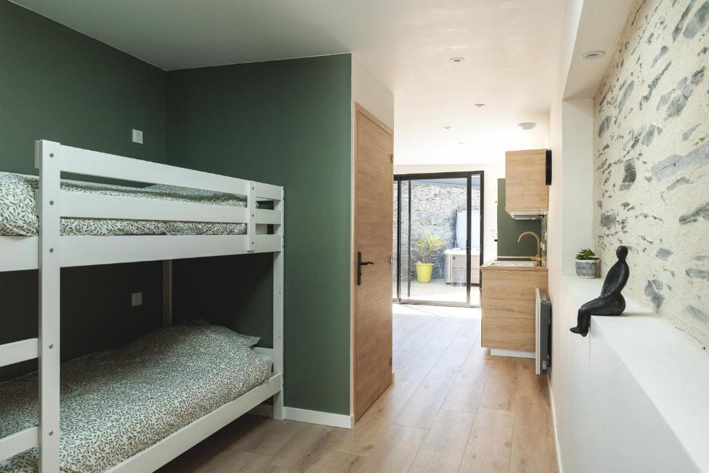 una camera con letto a castello e parete verde di Cosy home quartier gare lafayette avec spa et sauna privatif ad Angers