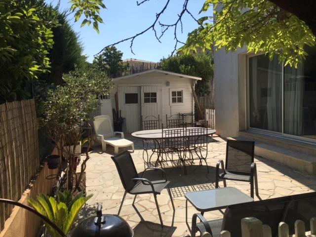 a patio with chairs and tables and a table at Studio meublé au calme avec terrasse et climatiseur mobile in Fréjus
