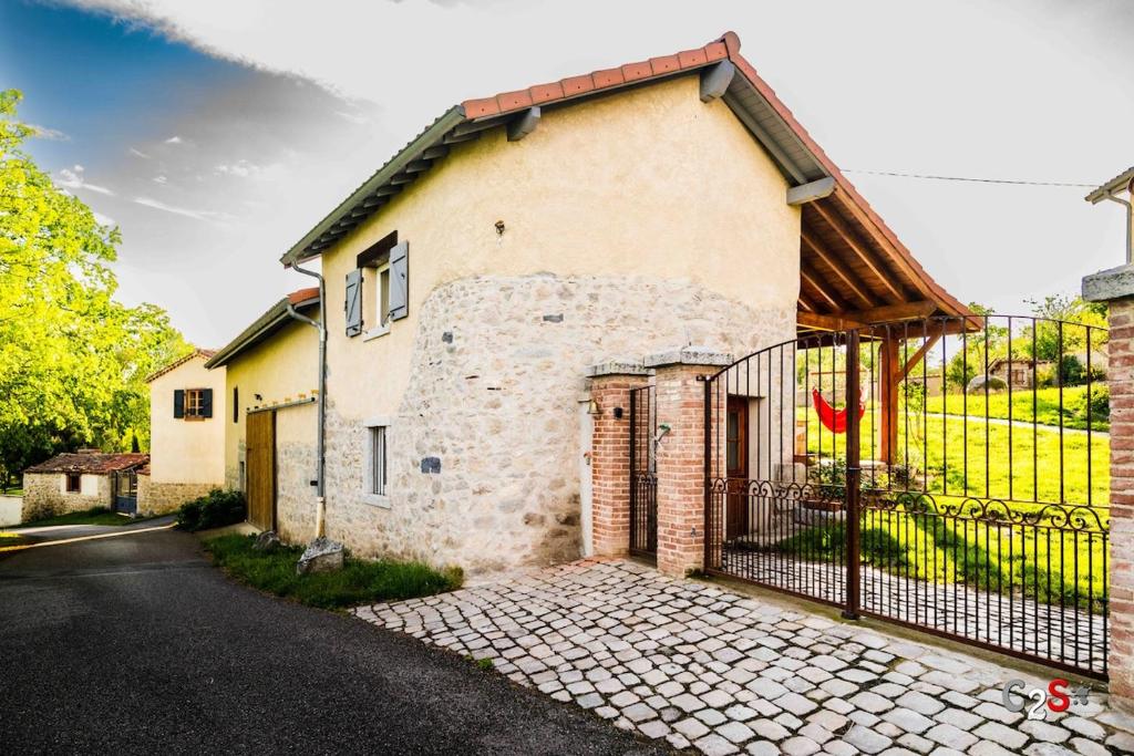 a stone house with a gate on a street at À la campagne in Cezay