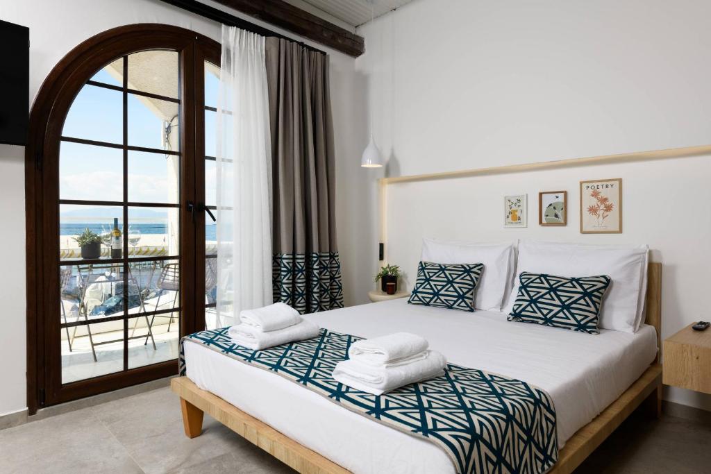 a bedroom with a large bed with a large window at Sea View Center 2 in Limenas