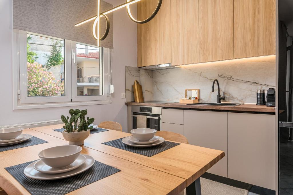 a kitchen with a wooden table with bowls and plates on it at Kourti Residence in Pefkohori