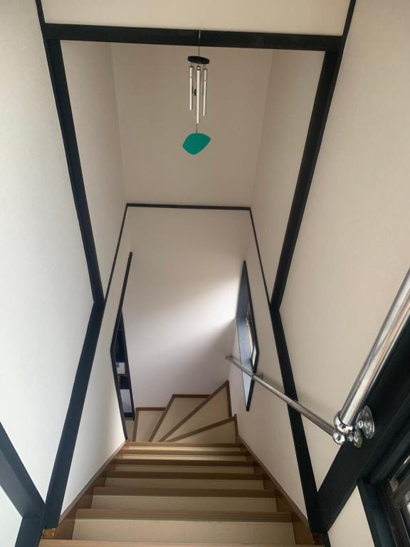 eine Treppe in einem Gebäude mit einem Kronleuchter in der Unterkunft 仁信小屋 in Tokio