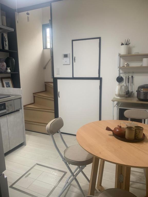 eine Küche mit Tisch und Kühlschrank in der Unterkunft 仁信小屋 in Tokio