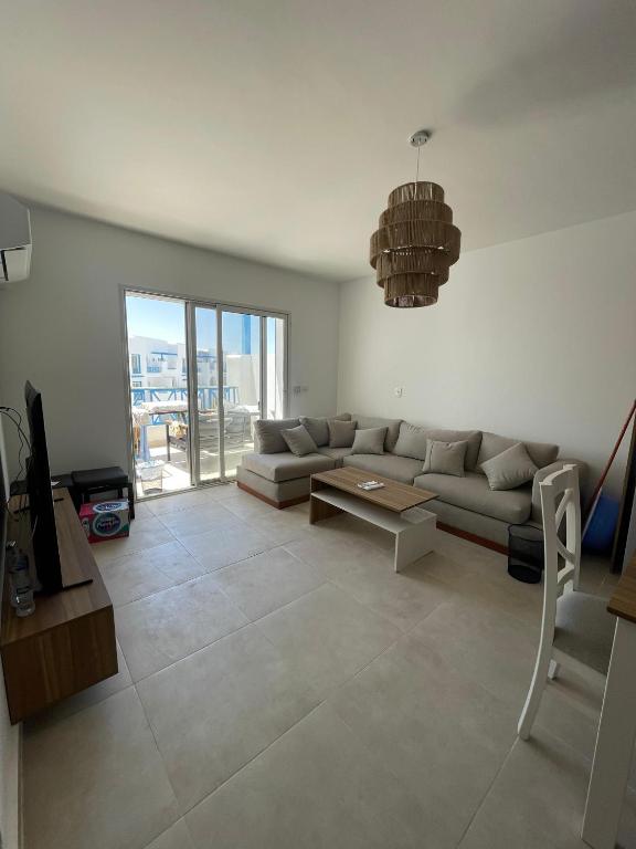 a living room with a couch and a table at Boho Breez Mountain View Chalet in Ras Elhekma