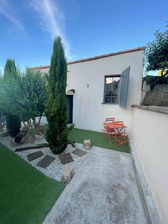 a garden with a table and a chair in front of a house at Charmant logement indépendant avec patio in Niort