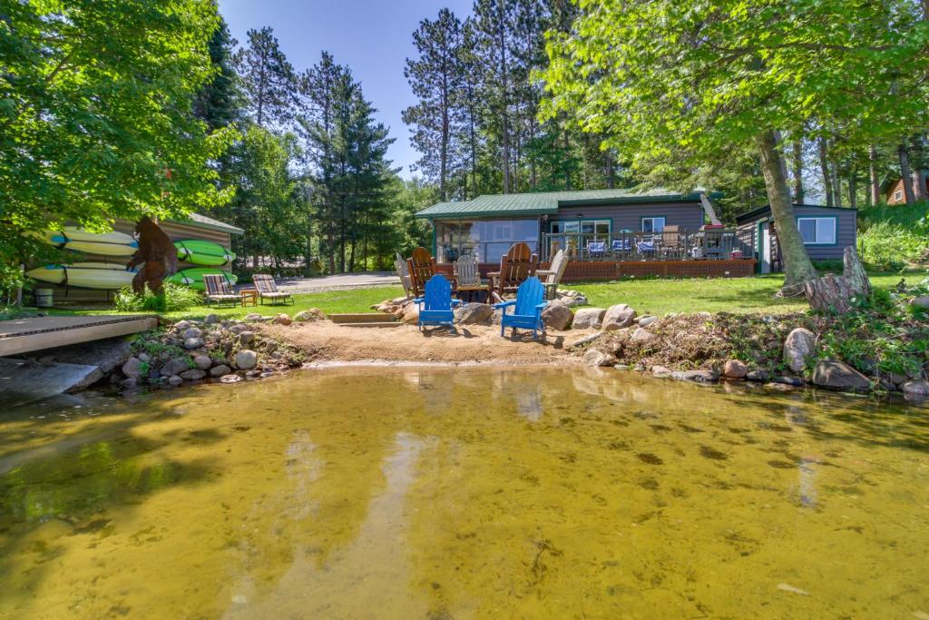 a house with a pond in front of it at Pequot Lakes Cabin with Dock on Loon Lake! in Pequot Lakes
