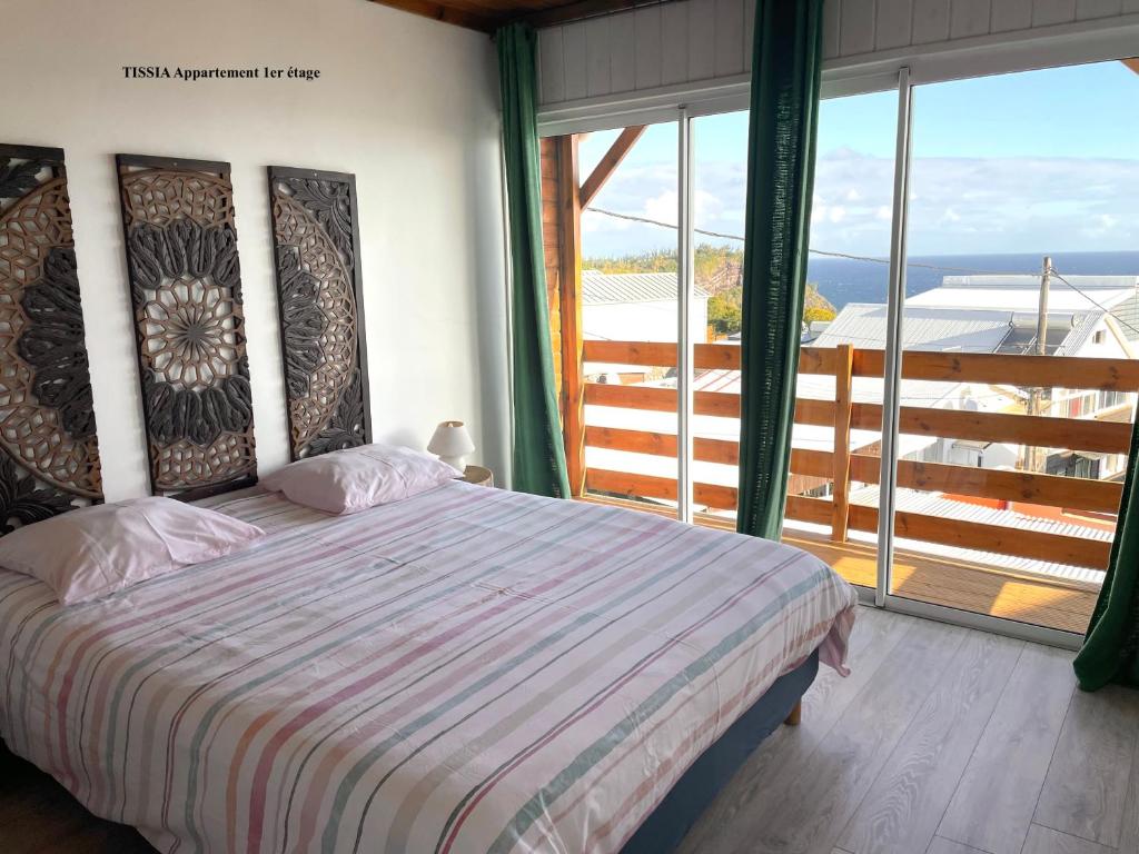 una camera da letto con un letto e una grande finestra di Alambic de Grand Anse a Petite-Île