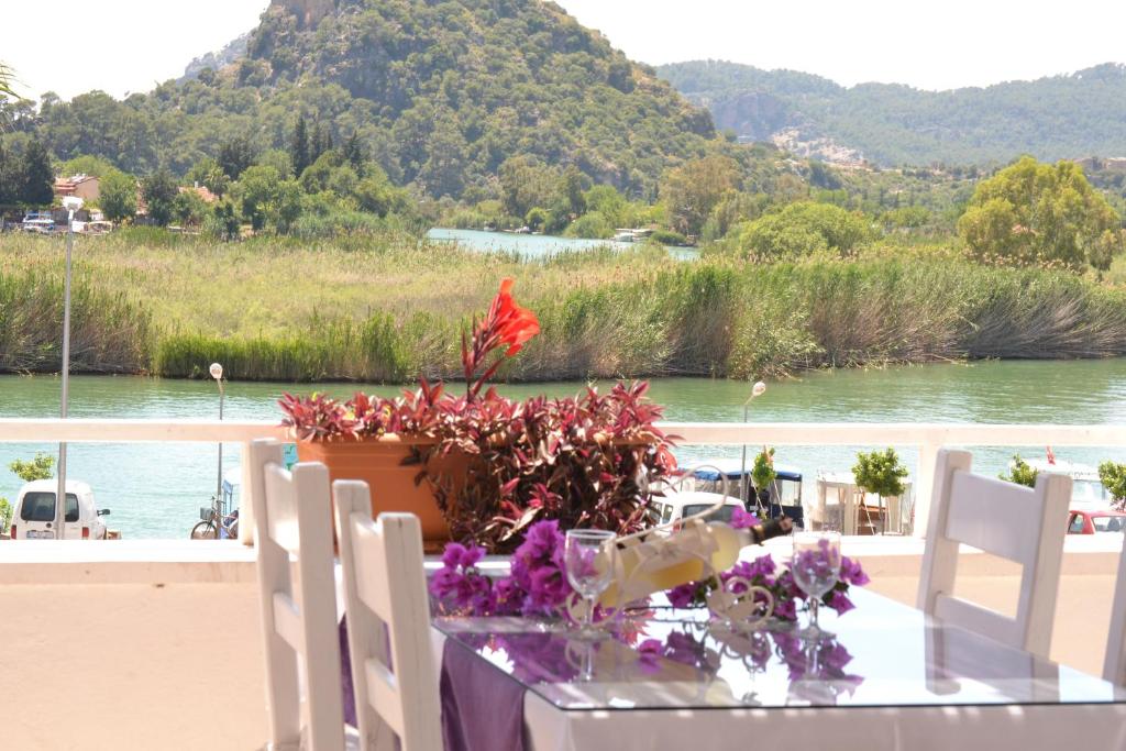 a table with chairs and a flower arrangement on it at Dalyan Terrace Hotel in Dalyan