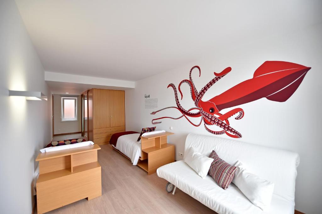 a room with a bed and a wall with a spider on it at Casa da Baía - Guest House in Horta