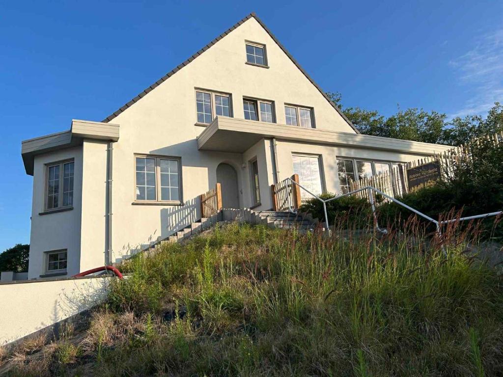a house on top of a grassy hill at Z' Evita in Nieuwpoort