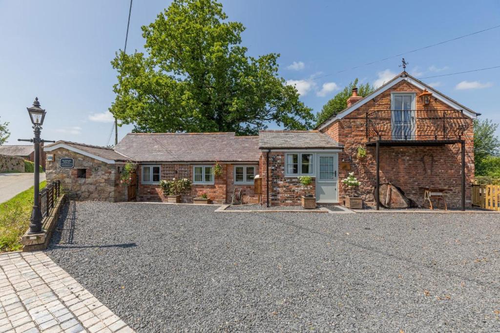 an old stone house with a gravel driveway at 2 Bed in Carreghofa oc-t32530 in Llanymynech