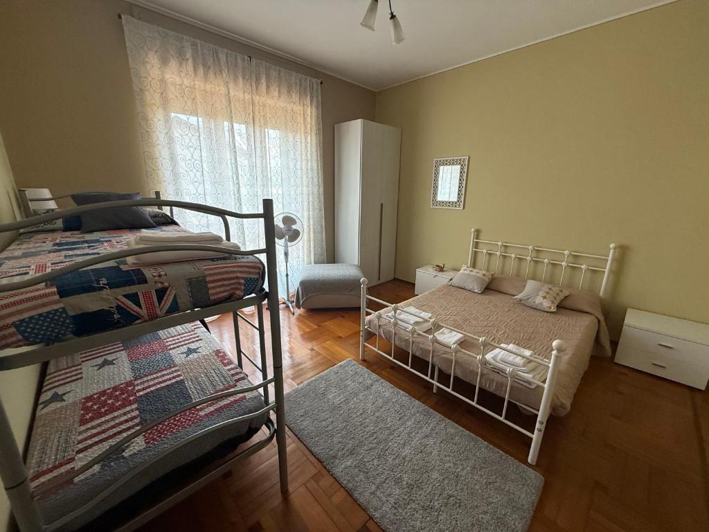 a bedroom with two bunk beds and a window at Affittacamere La CRICOVA di Iulia in Cervasca
