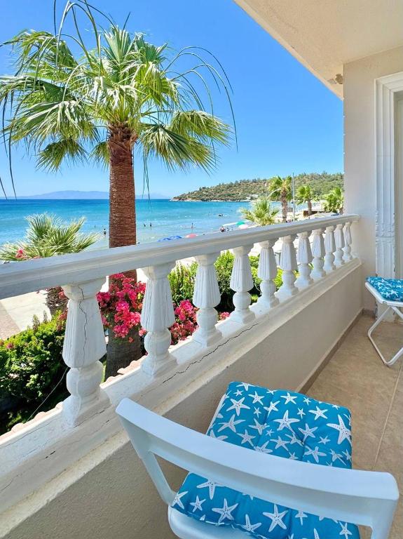 a balcony with a palm tree and the ocean at VITAMIN SEA Apartment in Özdere