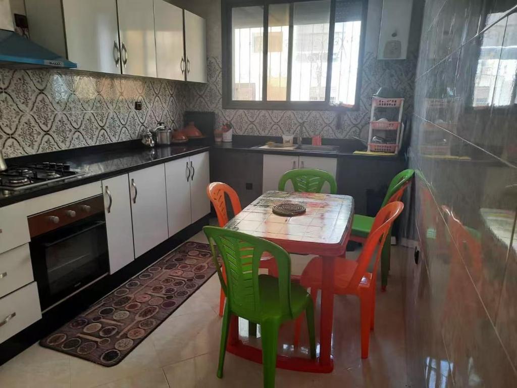 a kitchen with a table and chairs and a stove at Bouznika mandarona in Bouznika