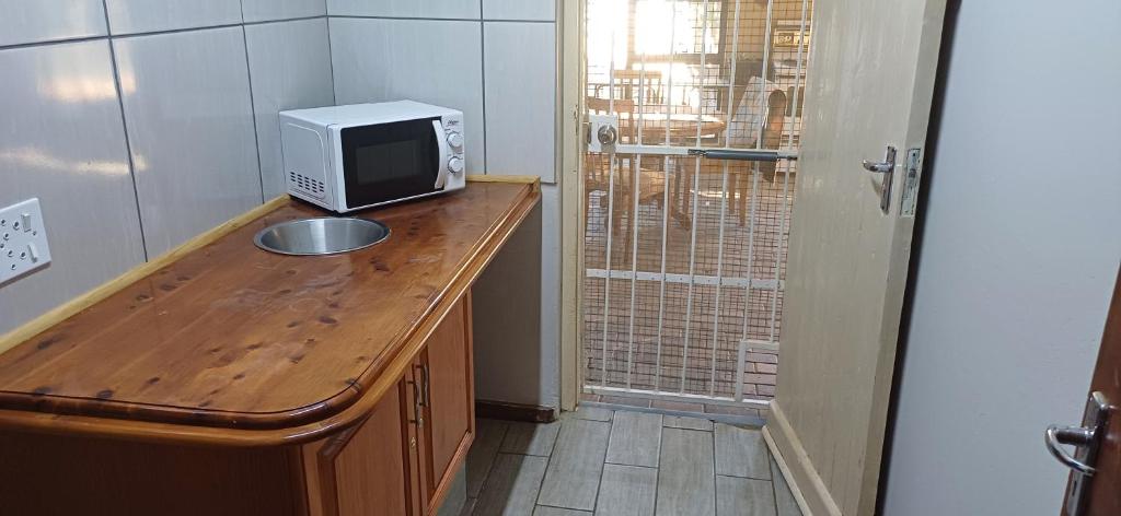 a kitchen with a tv on top of a wooden counter at Olive rest in Wesselsbron