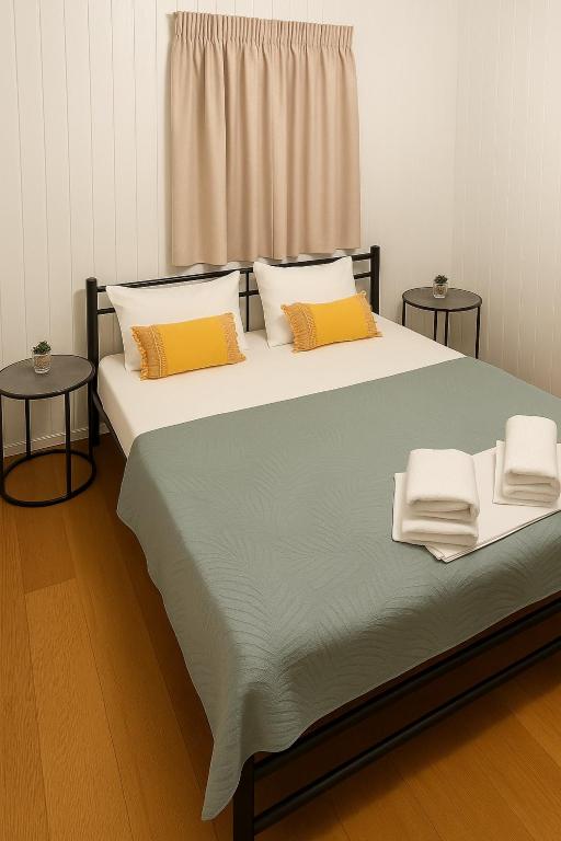 a large bed with two pillows and two tables at Kiki House in Nea Potidaea
