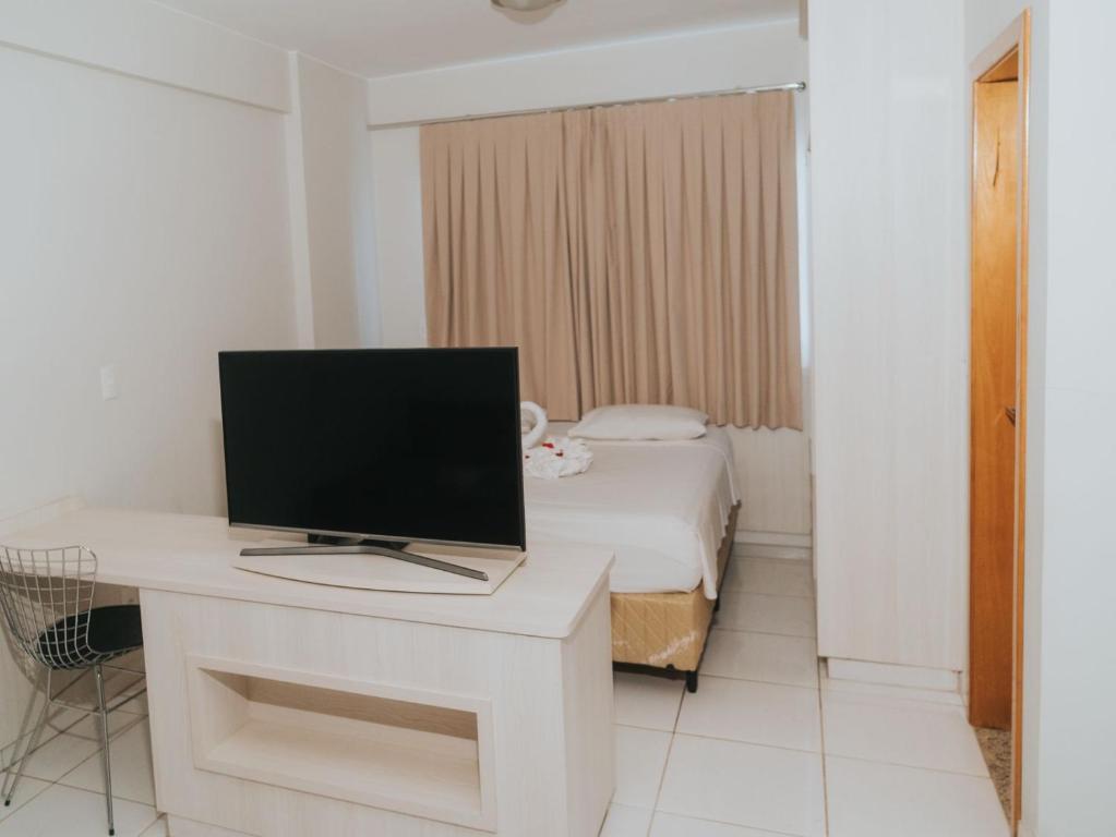 a room with a computer on a desk with a bed at Apto 207 - Golden Dolphin SUPREME in Caldas Novas