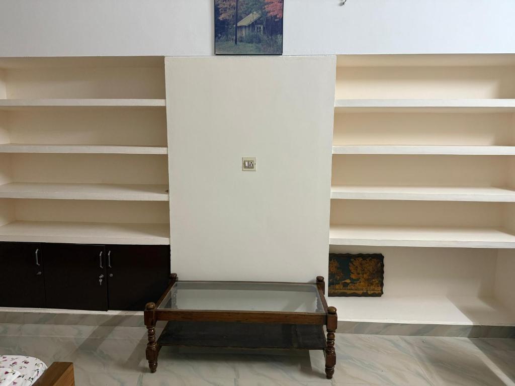 a room with white shelves and a bench at Bindas in Trivandrum