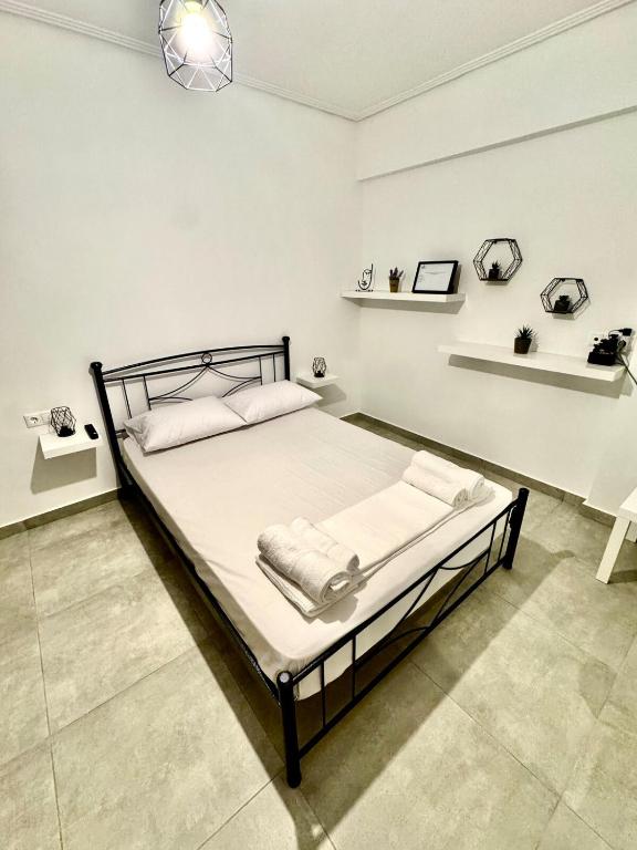 a bedroom with a bed in a white room at GuccisCozyStudio in Artemida