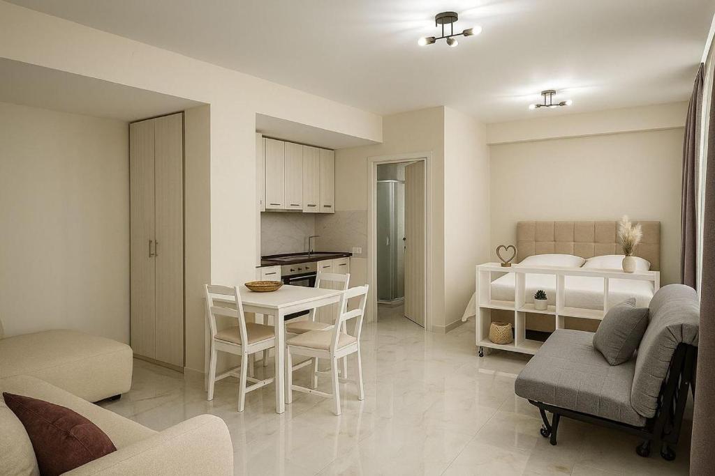 a kitchen and living room with a table and chairs at Studio Lumo in Nea Moudania