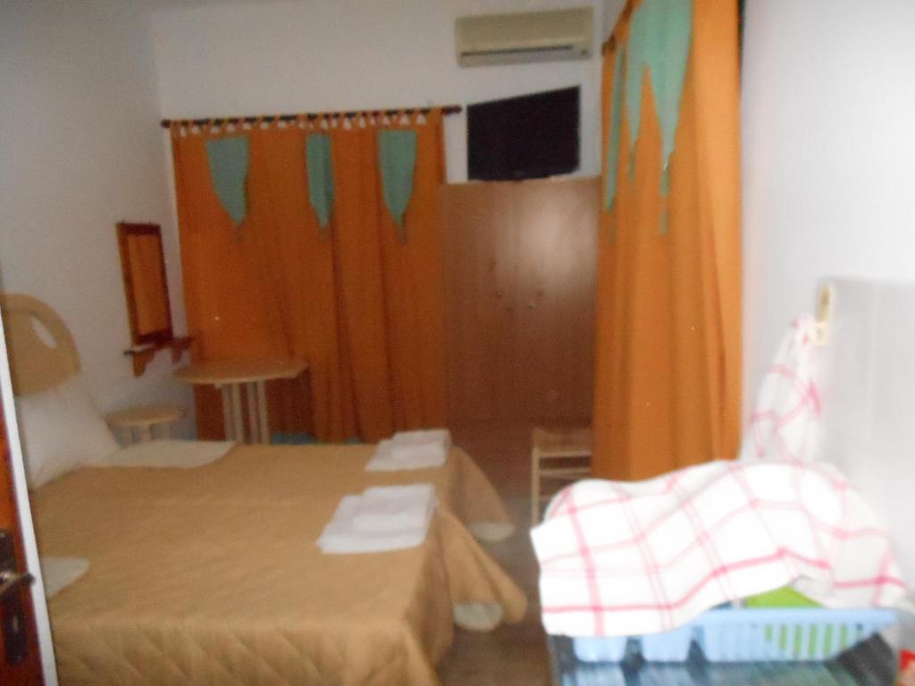 a room with a bed and a table and a curtain at Gyrouli Studios in Astypalaia