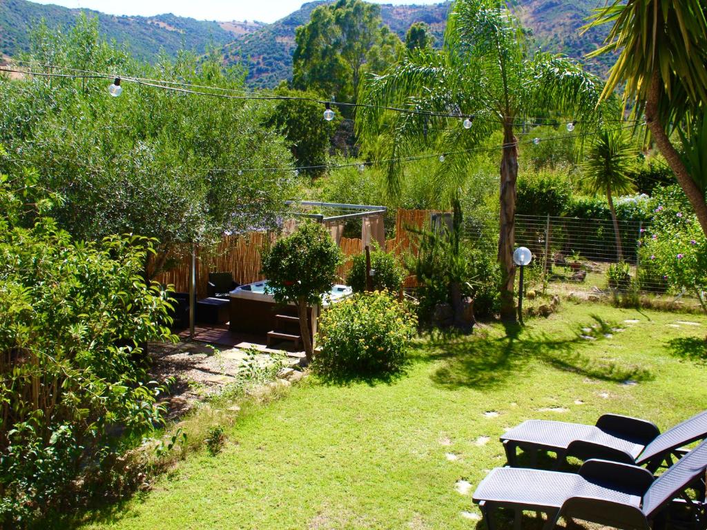 un giardino con un mucchio di panchine sull'erba di Villa Pelau - Holiday Home a Jerzu