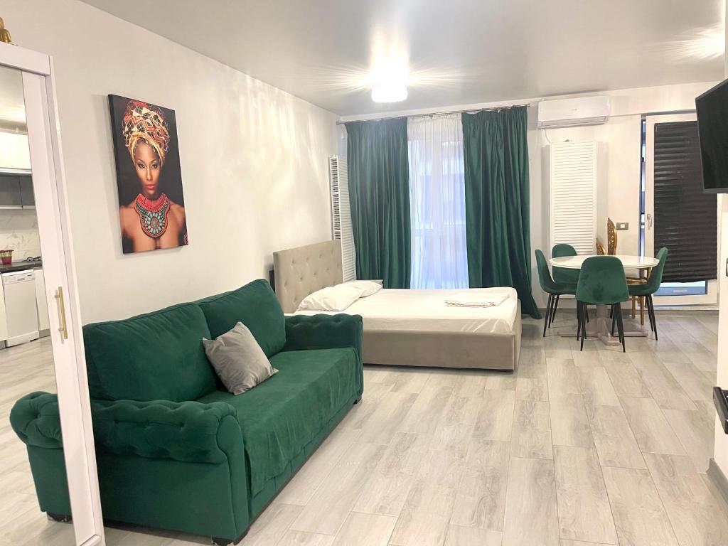a living room with a green couch and a bed at Studio Philip by Alezzii Nord 10 in Năvodari